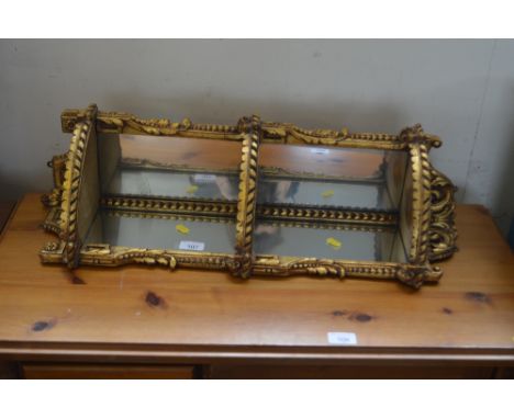 A gilt and wood mirror backed wall shelf