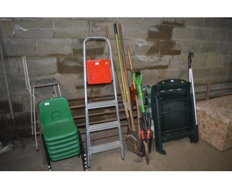 An aluminium step ladder together with a quantity of long handled tools