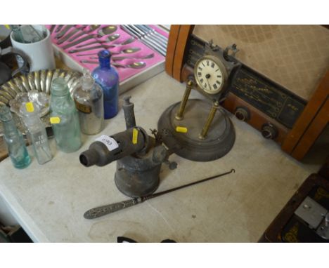 An anniversary clock in need of restoration together with a blow lamp and a button hook 