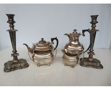 Silver plated tea set together with a pair of ornate candle stick