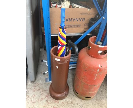 A TERRACOTTA STAND WITH STICK AND UMBRELLA