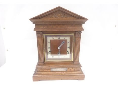 Eight day mantel clock in oak case of architectural style, 42cm high.