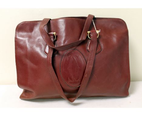 Muste de Cartier vintage maroon leather hand bag with twin loop handles and embossed monogram, 40cm.  Provenance Rita Tushing