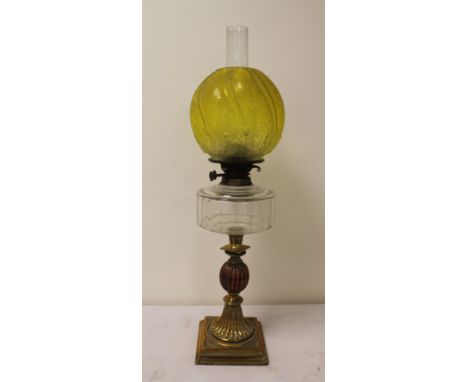 Oil lamp, the clear glass reservoir on brass and copper reeded knopped column, with etched yellow globular glass shade, 67cm 