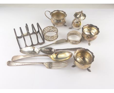 Silver part condiment set, four pieces, cased, a toast rack, three spoons, a fork and two napkin rings. Condition Report. 10o