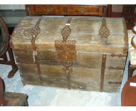 A 17th Century iron bound oak domed trunk
Flanked by twin carrying handles, some restoration and further damage throughout, w