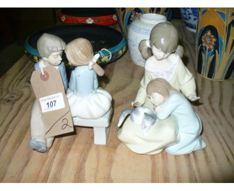 A Lladro group , two girls with a kitten and a Nao group boy and girl on a bench. (2)