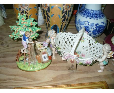 A Sittzendorf apple picking group.  Early twentieth century modelled from the Meissen original as a young boy on a ladder bal