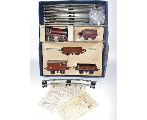 A Hornby 0 gauge No. 601 LMS goods set comprising of clockwork 0-4-0 LMS loco and tender, with three coaches, circle of track