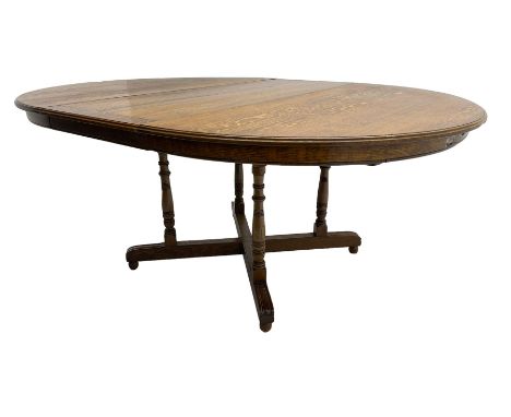 Early 20th century oak dining table, circular extending top with telescopic action, on four pillar base with x-framed platfor