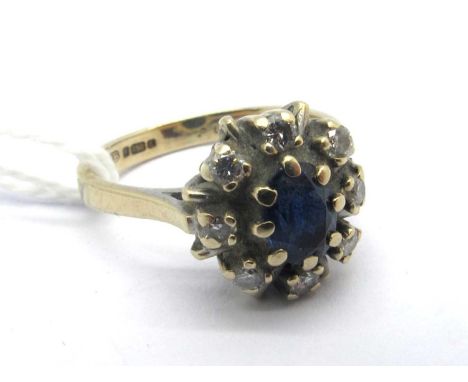 An 18ct Gold Sapphire and Diamond Cluster Ring, oval claw set to the centre, within border of brilliant cut stones (finger si