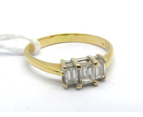 A Modern 18ct Gold Millennium Cut Three Stone Diamond Ring, graduated rectangular claw set, stamped "50" (finger size R).The 