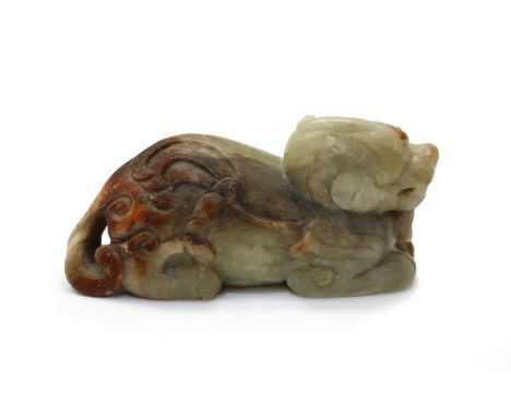 A Chinese jade carving, of a recumbent mythical beast, its furs depicted in detailed archaic scrolls, the stone of celadon to