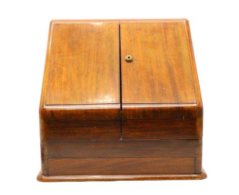 An Edwardian mahogany stationery cabinet, having pair of sloping doors enclosing fitted interior with calendar and inkwell, 3