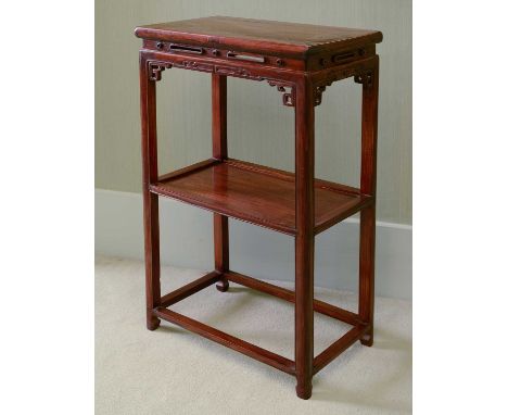 A Chinese rosewood occasional table, 20th century, the rectangular top with a pierced and carved apron, the square section le