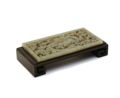 A Chinese jade plaque, carved with a dragon amongst clouds, fixed to a wood stand, 12.7cm longCondition report: Small chips t