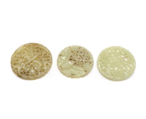 Three Chinese jade plaques, pierced and carved with a Shou character, comprising one surrounded by phoenixes, 5.3cm diameter,