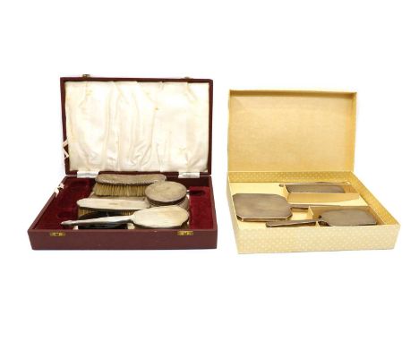 A cased silver dressing table set, comprising hair brush, mirror, comb and clothes brush, London 1947, a similar silver four 