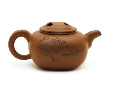 A Yixing zisha teapot and cover, of shaped square form with incised lotus flowers to one side and an inscription to the other
