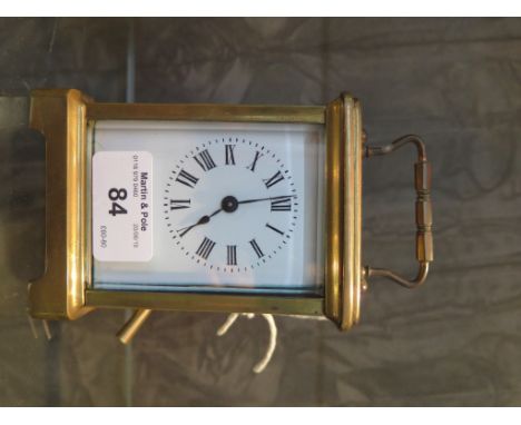 A brass carriage time piece with enamel dial, and single train movement 14cm high