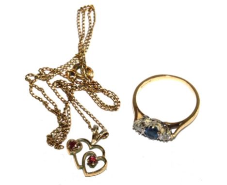 An 18 carat gold ring set with two diamonds and a sapphire together with a ruby pendant