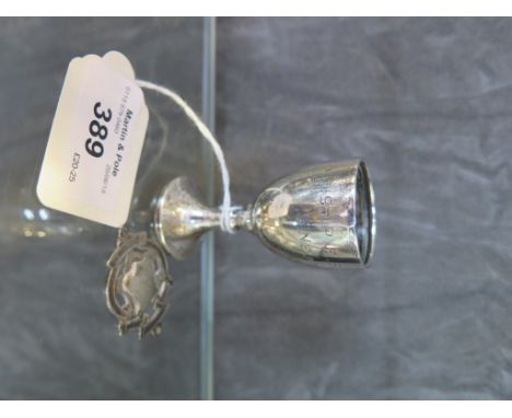 A silver egg cup and a silver candlestick