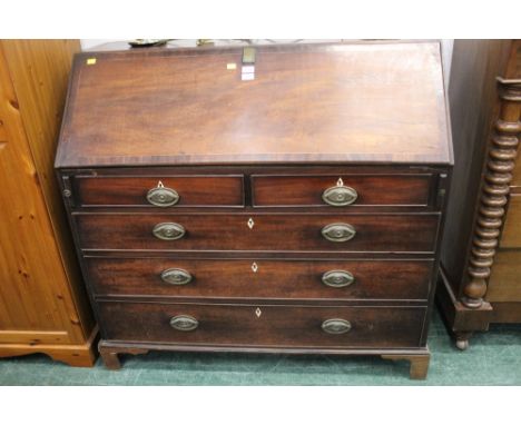 George III mahogany bureau, with slope front to well fitted interior, with series of frieze drawers with brass drop handles w