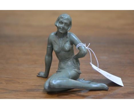 A 1920's patinated bronze figure of a seated flapper with green patina (possiby originally a clock mount).  13.5cm