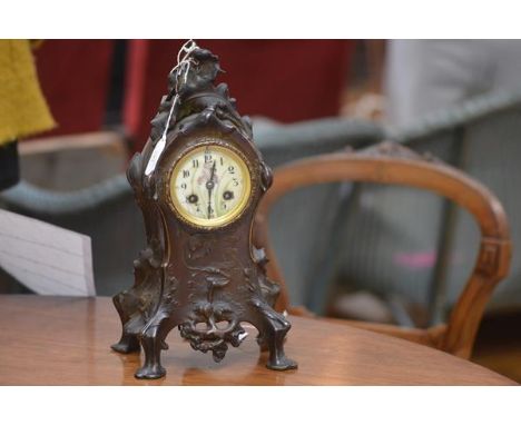 A French patinated bronze mantel clock, c. 1900, the case cast and chased in the Art Nouveau taste with lilies and poppies an