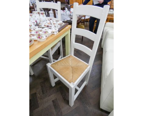 A set of four chunky, white painted, ladder back dining chairs with rush seats 