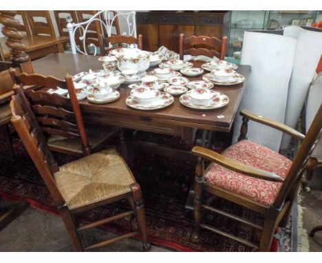 A large dark oak refectory style pullout extending dining table and a set of six ladder back dining chairs comprising of four