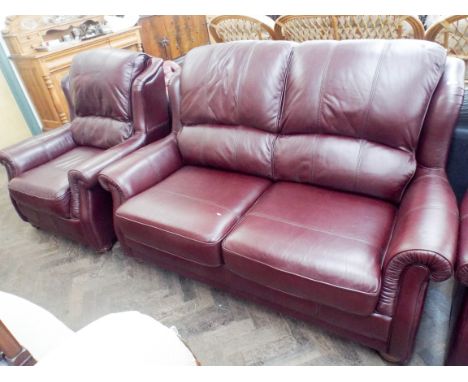 A Burgundy leather two seater sofa and a pair of matching armchairs 