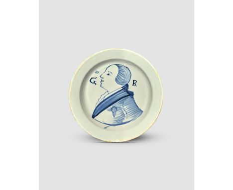 GEORGE III A London delftware plate, c.1760, well painted in blue with a head and shoulders profile portrait of the king pinn