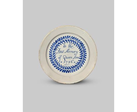 1716 QUEEN ANNE IN MEMORIAM A delftware plate, dated 1716, painted in blue with the inscription 'To the Pious Memory of Queen