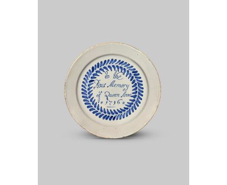 1716 QUEEN ANNE IN MEMORIAM A delftware plate, dated 1716, painted in blue with the inscription 'To the Pious Memory of Queen