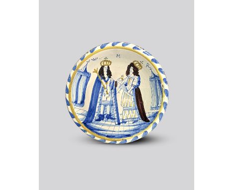 WILLIAM AND MARY A London delftware Royal blue dash charger, c.1690, painted in blue, yellow and manganese with full-length p