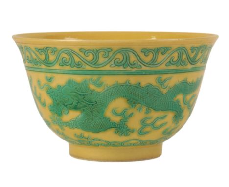 A CHINESE YELLOW-GROUND GREEN ENAMLLED 'DRAGON' BOWL Qing or later, the dragons contesting flaming pearls within cloud-scroll