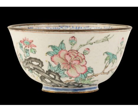 A CHINESE CANTON ENAMEL FAMILLE ROSE WINE CUP Qianlong, delicately painted with flowers and rockwork, 7cm diameter