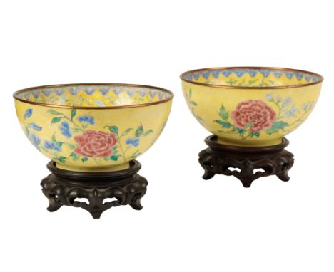 A PAIR OF CHINESE CANTON ENAMEL YELLOW GROUND BOWLS probably early Qing, painted with flowers around central fruit medallions