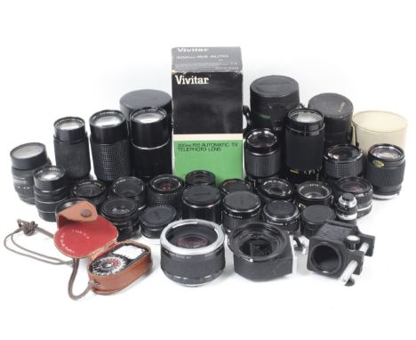 An assortment of camera lenses and len accessories. To include a Komura Telemore95 teleconverter for Pentax 67, an M42 mount 