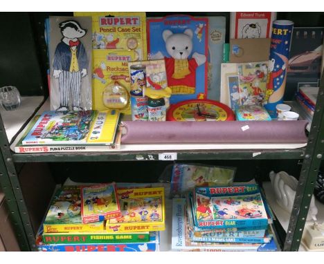 2 shelves of Rupert the Bear memorabilia including games, puzzles, puppet, clock etc.