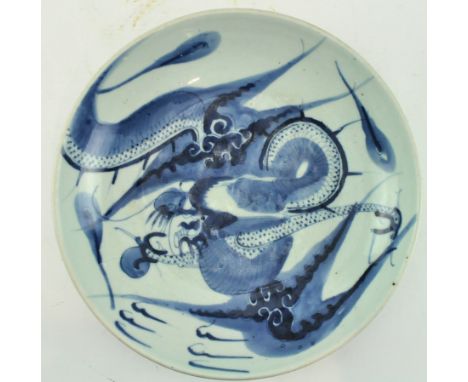 A Qing dynasty blue and white ceramic "Dragon" ceramic charger plate. The charge plate decorated with a dragon chasing a flam