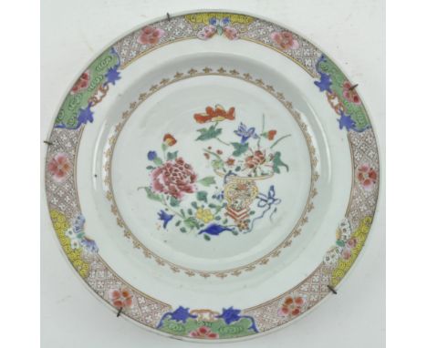 A Qing dynasty Yongzheng period famille rose ceramic charger plate. The ogee shaped charger decorated with peony and a vase w