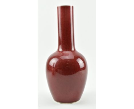 A late Qing or later sang de boeuf ox blood red glazed ceramic bottle vase. Ovid body with a tall cylindrical neck covered in
