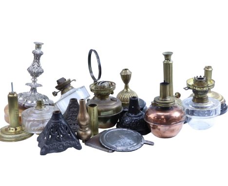 A quantity of oil lamp parts, including cast iron bases, cut glass and brass fonts, etc