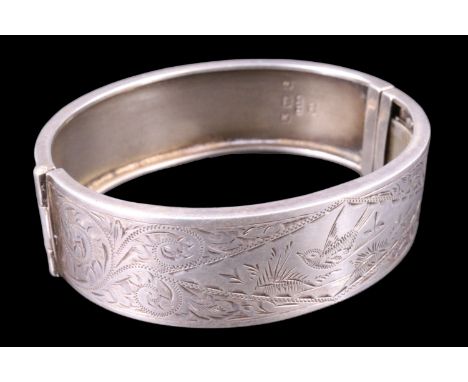 A 1930s silver bangle, bright cut decorated in depiction of a swallow gliding over a pond in a border of foliate scrolls, Ken
