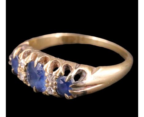 An Edwardian sapphire and diamond ring, having an oval 5 x 4 mm sapphire set between two 3 mm brilliants, each divided by two