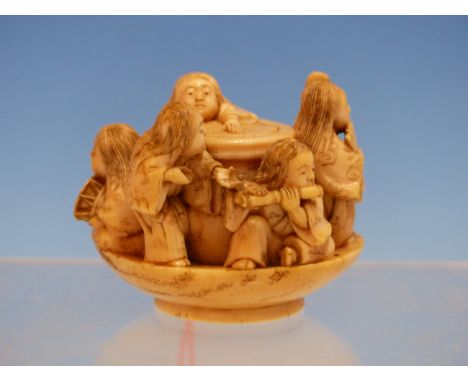 TOMOMASA, AN IVORY OKIMONO OF SIX CHILDREN PLAYING MUSIC AND DANCING WITHIN A SAUCER, SIGNED.   Dia. 5.5cms