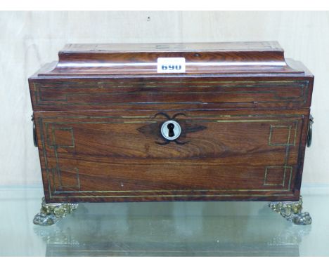 A REGENCY ROSEWOOD AND BRASS INLAID SARCOPHAGUS FORM TEA CADDY WITH BRASS RING HANDLES AND FEET.   W.32cms.