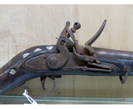 AN INDIAN ADAPTED FLINTLOCK MUSKET WITH RAMROD, THE STOCK INLAID WITH MOTHER OF PEARL, THE POLYGONAL BARREL BOUND BY COPPER S
